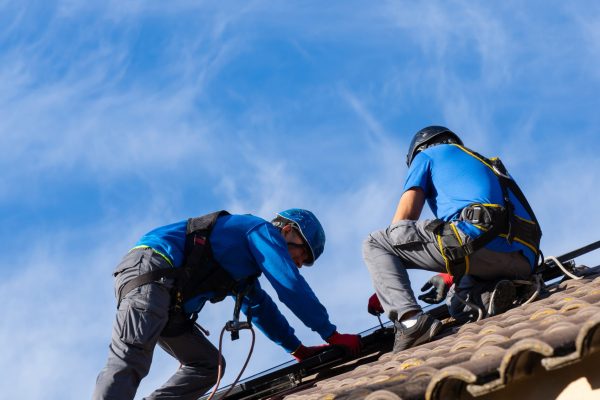Solar panel installers working on the roof of a house